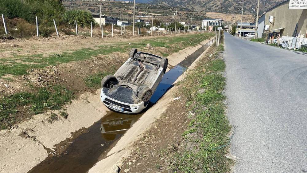 Kanala uçup ters dönen araçtan burunları bile kanamadan çıktılar