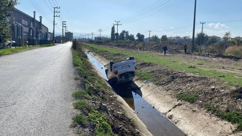 Kanala uçup ters dönen araçtan burunları bile kanamadan çıktılar