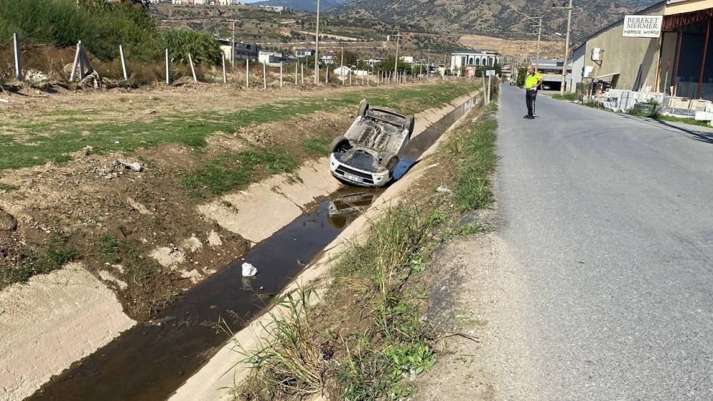Kanala uçup ters dönen araçtan burunları bile kanamadan çıktılar